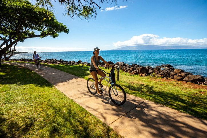 Kaanapali, Hawaii, USA - December 31, 2015: Women cycling along the beach, Maui